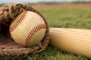 Baseball in glove with a bat